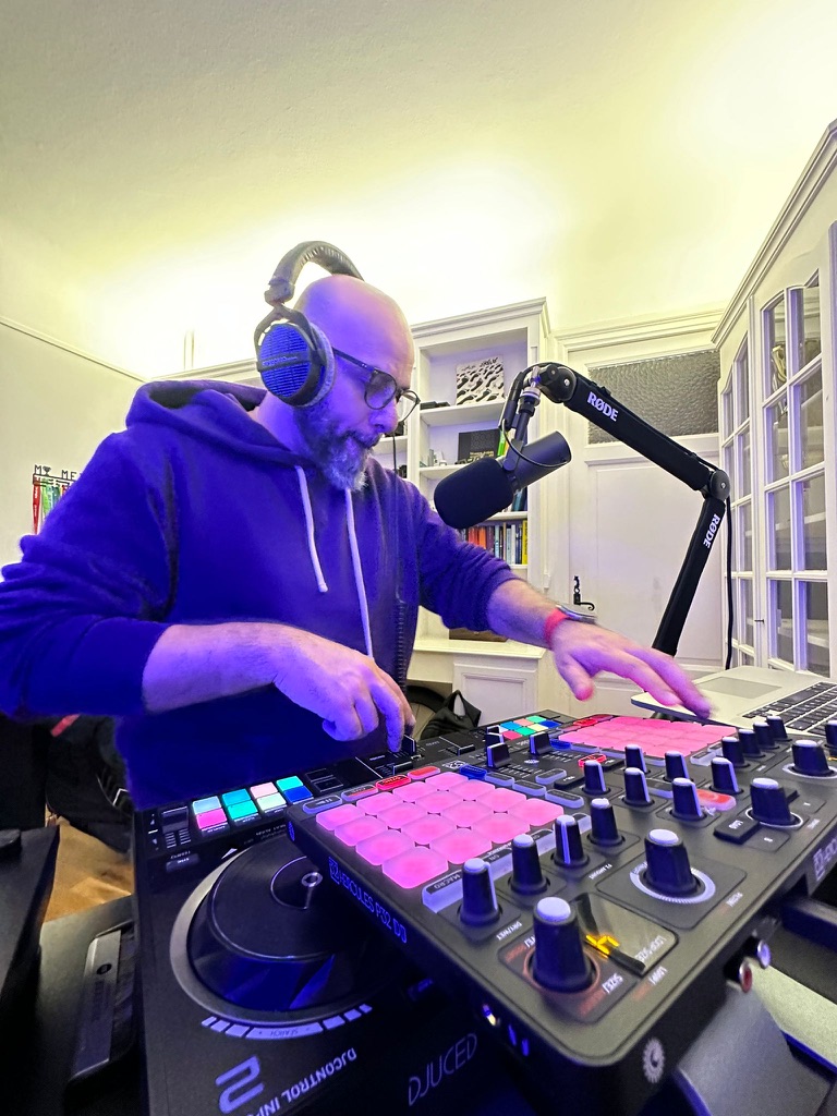 Nabil at his DJ controller, wearing headphones in his music room